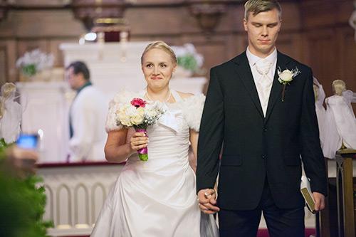 Nygift par går hand i hand i kyrkan